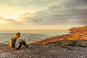 Woman meditating overlooking beach